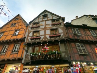 Colmar, Fransa - 30 Aralık 2021: Colmar, Petit Venedik, dar sokak ve geleneksel yarı ağaçlı evler kışın Noel süslemeleri ile birlikte .