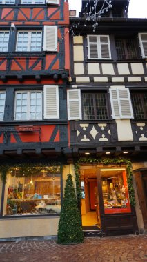 Colmar, Fransa - 30 Aralık 2021: Colmar, Petit Venedik, dar sokak ve geleneksel yarı ağaçlı evler kışın Noel süslemeleri ile birlikte .