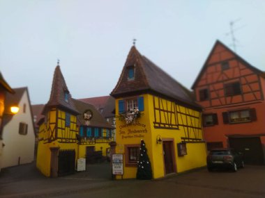 Eguisheim, Alsace, Fransa - 30 Aralık 2021: Fransa 'nın Alsace şarap bölgesinde geleneksel bir köy olan Eguisheim' da sabah sahnesi, şimdi geleneksel bir ev, bir şarap degustation mekanı.