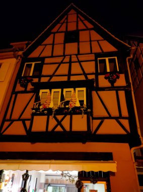 Fransa 'nın Alsace bölgesinde geleneksel bir köy olan Eguisheim' da bir gece sahnesi. Geleneksel bir ev, şimdi de şarap dezenfekte yeri.