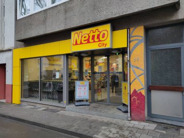 Aachen, Almanya - 3 Ocak 2022::: Netto mağaza ağının logosu ve markası, bir pazar mağazasının girişinin üzerinde siyah arkaplan üzerine sarı harflerle yazılmış..