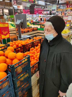 Süpermarketteki maskeli yaşlı kadın. Covid-19, sağlık, güvenlik ve salgın konsepti