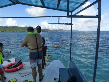 Roatan, Honduras - 26 Nisan 2022: İnsanlar Roatan, Honduras 'taki Karayip Denizi' nde su altında şnorkelle yüzme ve balıkçılık turu yapıyorlar.