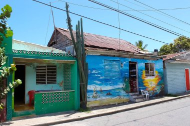 Puerto Plata, DR - 04 Mayıs 2022: Puerto Plata, Dominik Cumhuriyeti 'nin merkezindeki binaların yakınlarındaki dükkanlar ve tablolar