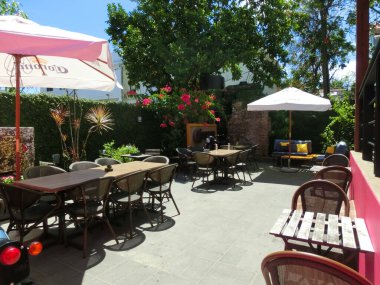 Puerto Plata, Dominik Cumhuriyeti - 4 Mayıs 2022: Pembe sokağa yeşil bitkiler, pencereler, sokak lastikleri, eski şehir, Puerto Plata, Dominik Cumhuriyeti 'nde dekoratif Karayip çevresi olan insanlar.