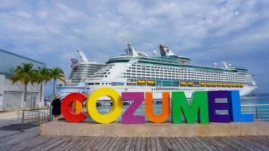 Cozumel, Mexico - May 04, 2022: Royal Carribean cruise ships docked in the Cozumel port during one of the Western Caribbean cruises at Cozumel, Mexico on May 04, 2022. Welcome sign in front of cruise ship. clipart
