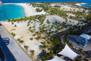 Bahamalar 'daki Ocean Cay adasındaki plajda dinlenen insanlar. Mavi su ve beyaz kum
