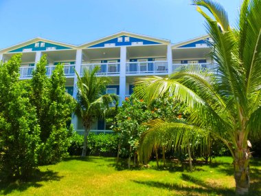 Okyanus kıyısındaki Cay Bahamalar Adası 'nda renkli evleri ve tropik geçmişi olan plaj.