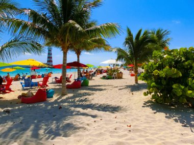 Bahamalar 'daki Ocean Cay adasındaki plajda dinlenen insanlar. Mavi su ve beyaz kum