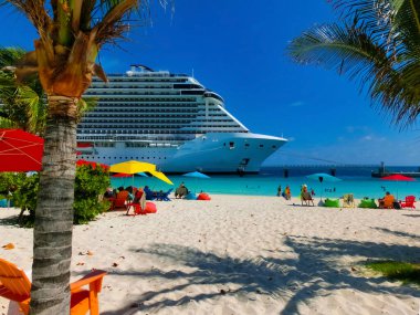Bahamalar 'daki Ocean Cay adasındaki plajda dinlenen insanlar. Mavi su ve beyaz kum