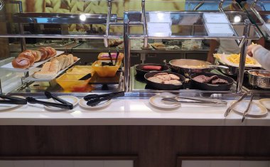 Soyut lüks yolcu gemisinde yemek odası büfesi. Seçici odaklanma. Yağda yumurta ve pastırma.