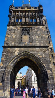 Prag, Çek Cumhuriyeti - 11 Mayıs 2022: Vltava Nehri 'nin girişine bakan tarihi Charles Köprüsü üzerinde yürüyen insanlar.