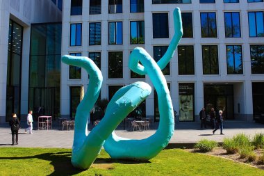 Frankfurt am Main, Almanya - 20 Nisan 2022: Frankfurt 'taki modern ofis kuleleri arasında bir parkta soyut heykel