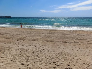 Dania beach, Florida, USA - May 09, 2022: Long distance view of the sunny and tropical blue water shoreline at Dania beach