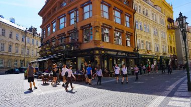 Prague, Czech Republic - May 11, 2022: The people going near houses of old architecture in old town at Prague, Czech Republic