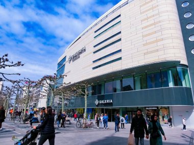 Frankfurt am Main, Germany - May 10, 2022: Galeria Kaufhof at the Zeil, close to Hauptwache. Corner view with several logos, signs, glass facade, terrace and people in front of the building.