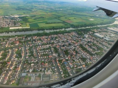 Airplane window view of wing, highway junctions and green forest at Frankfurt am Mine, Germany