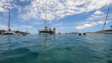 Suyun altında şnorkelle yüzen insanlar ve tekneyle ABD Virjin Adaları 'ndaki USVI, St. Thomas' taki Karayip Denizi 'nde geziyorlar.