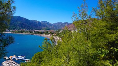 Marmaris Town 'daki Icmeler Sahili manzarası. Türkiye 'nin Akdeniz kıyısında yaz manzarası. Koy manzarası ve çam dalları arasında dağlar