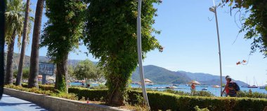 Marmaris, Türkiye - 22 Eylül 2022: Deniz kenarına karşı mavi deniz ve dağların manzaralı körfezi. Marmaris. Türkiye