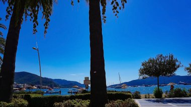 Marmaris, Türkiye - 22 Eylül 2022: Deniz kenarına karşı mavi deniz ve dağların manzaralı körfezi. Marmaris. Türkiye