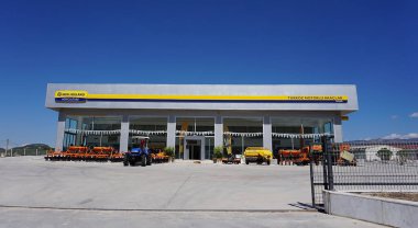 Araclar, Türkiye - 16 Eylül 2022: Araclar, Türkiye - 16 Eylül 2022 tarihleri arasında New Holland Tarım mağazasında mavi gökyüzüne karşı. Tarım makinelerinin küresel markasının sembolüdür.