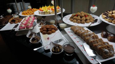 Açık büfedeki raflarda bulunan yiyecekler, Türkiye 'de soyut otel veya Kemer' deki tatil beldesindeki her şeyi kapsıyor. Tatlı kekler ve tatlı