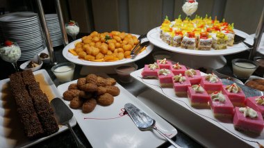 Açık büfedeki raflarda bulunan yiyecekler, Türkiye 'de soyut otel veya Kemer' deki tatil beldesindeki her şeyi kapsıyor. Tatlı kekler ve tatlı