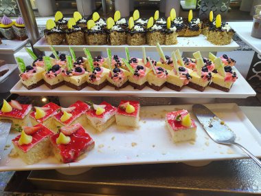 Açık büfedeki raflarda bulunan yiyecekler, Türkiye 'de soyut otel veya Kemer' deki tatil beldesindeki her şeyi kapsıyor. Tatlı kekler ve tatlı