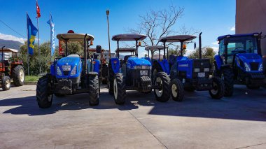 Araclar, Türkiye - 16 Eylül 2022: Araclar, Türkiye 'de traktör ve mavi gökyüzü üzerine New Holland tarım logosu - 16 Eylül 2022. Tarım makinelerinin küresel markasının sembolüdür.