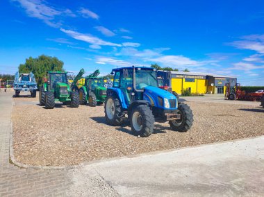 Araclar, Türkiye - 16 Eylül 2022: Araclar, Türkiye - 16 Eylül 2022 'de Türkiye' nin Araclar kentinde mavi gökyüzüne karşı traktör üzerinde New Holland Tarım logosu. Tarım makinelerinin küresel markasının sembolüdür.