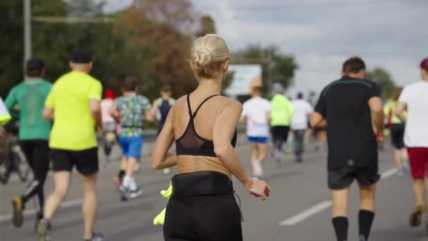 Бегунья проверяет сердцебиение во время марафона — стоковое видео