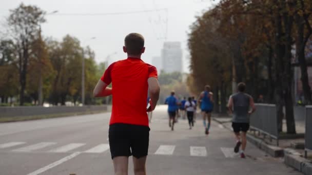 Человек бежит марафон со смартфоном в руке — стоковое видео