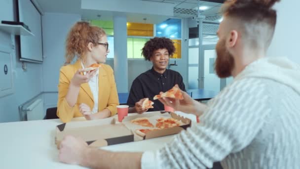 Друзья едят пиццу и веселятся на рабочем месте — стоковое видео