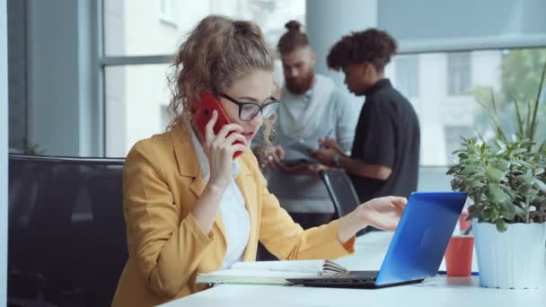 Femme travaillant au bureau et parlant au téléphone — Video