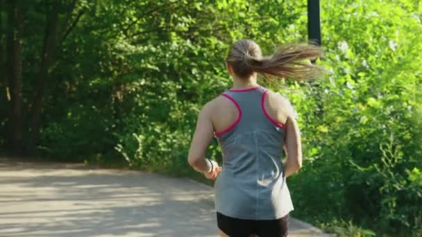 Mujer de cámara lenta corriendo en el parque en verano — Vídeo de stock