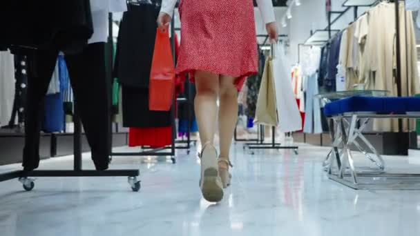 Pies de mujer caminando con bolsas de compras en el centro comercial — Vídeos de Stock