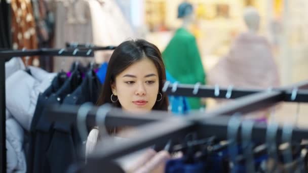 Mujer asiática de compras en tienda de ropa — Vídeos de Stock