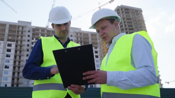 Hombres estrechando las manos después de firmar contrato en el sitio de construcción — Vídeos de Stock