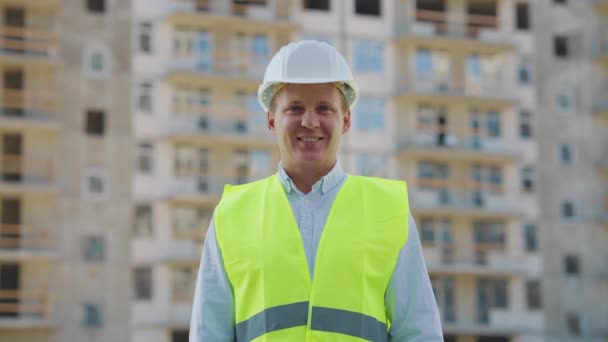 Ingeniero civil sonriendo a cámara contra rascacielos — Vídeos de Stock