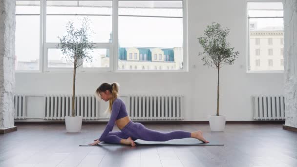 Donna che pratica pose sedute in classe di yoga — Video Stock