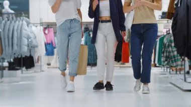 Kadınlar elbise mağazasında birlikte yürüyorlar.