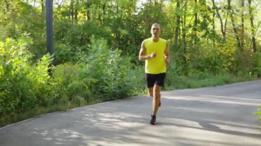 Atletik adam sabah güneşinde koşuyor