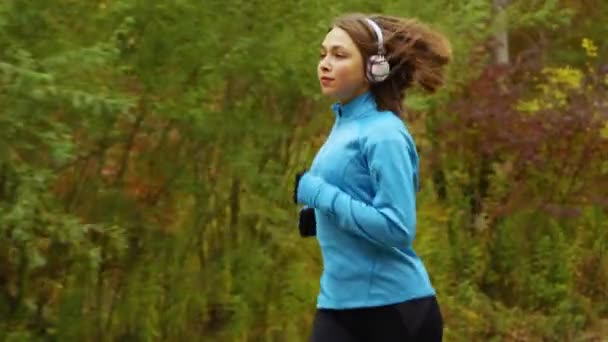 Fit Vrouw Met Een Blauw Jasje Zwarte Handschoenen Joggen Natuur — Stockvideo