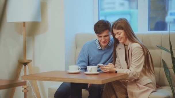 Kochająca Się Para Siedząca Kawiarni Oglądająca Zdjęcia Smartfonie Mówiąca Uśmiechnięta — Wideo stockowe