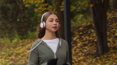 Kulaklıklı, spor kıyafetli ve eldivenli genç bir kadın ağır çekimde koşuyor, yaprakları yere düşmüş. İzleme çekimi serin bir sonbahar sabahı egzersiz yapan bir kadına uyuyor. Zindelik kavramı