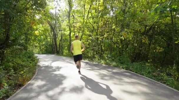 Slow motion jogger draait op gevorkte weg — Stockvideo