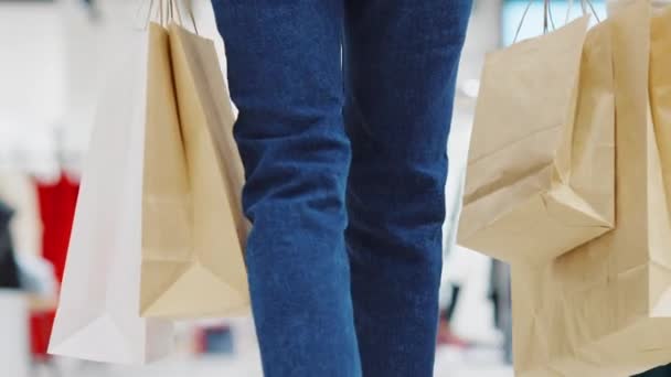 Mujeres llevando bolsas de papel en el centro comercial — Vídeos de Stock