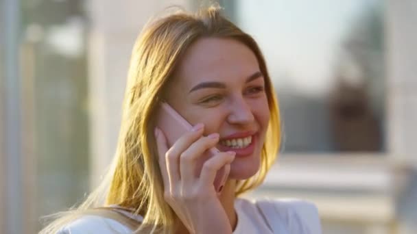 Szczęśliwa kobieta rozmawia przez telefon na ulicy o zachodzie słońca — Wideo stockowe