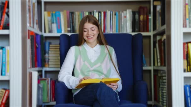 Женщина смеется над смешной книгой в магазине — стоковое видео